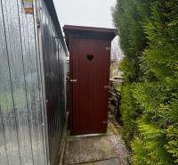 Garden toilet next to the metal shed behind the cottage in Nové Zámky.