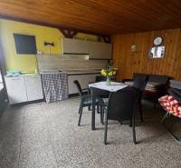 Covered terrace in a cabin with wooden decor, comfortable furniture, and a table for relaxation.