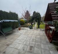 A cottage in Nové Zámky with a paved terrace and a swing in the garden.