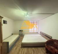 Bedroom in a 2-room apartment with a bed, wardrobe, and floor with wooden decor.