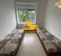 Cozy room in a 3-room apartment with two beds and a view of greenery.