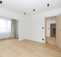 A room with a wooden floor decor and curtains in a 3-room apartment.
