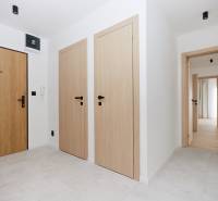 A bright hallway with wooden doors and a curtain in a 3-room apartment.