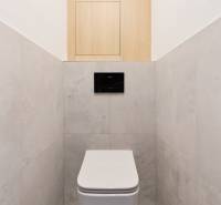 A bathroom with a simple design in a 3-room apartment, white and wooden elements.