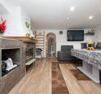 Living room with a fireplace, sofa set, and table; floor with wood decor.