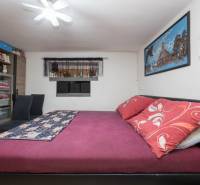 Bedroom with a double bed, wardrobes, and decorations in a family house.