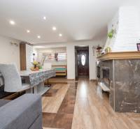 Living room in a family house, with a wooden decor floor and a fireplace.