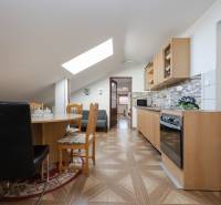A kitchen in a family house with a dining table, wooden decor flooring.