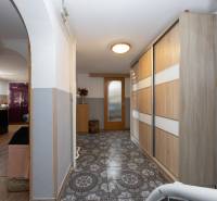 A hallway with tiling, a built-in wardrobe, and an arched passage in a family house.