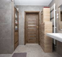 Bathroom in a family house with wooden decor and ceramic tiles.