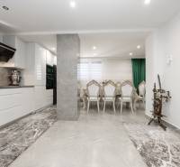 Kitchen and dining room with chairs in a family house; stone floor and traditional spinning wheel.