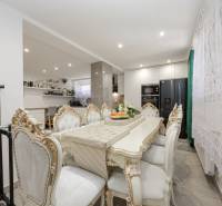 Dining table and chairs in a family house with richly decorated design.