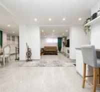Interior of a family house with a dining area, living zone, and wooden decor flooring.