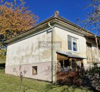 A family house in Malá Lehota with a white facade and fencing in an autumn setting.