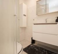 A bathroom in a 3-room apartment with a modern shower and white furniture.