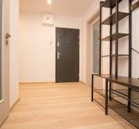 The entrance hall of a 3-room apartment with a wooden decor floor and metal furniture.