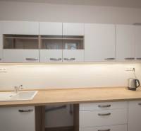 A kitchen unit in a 2-room apartment with a wooden decor countertop.