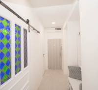 A hallway with stained glass doors, coat racks, and wooden decor in a 2-room apartment.