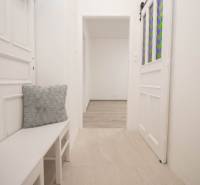 A bright hallway with white furniture and decorative cushions in a 2-room apartment.