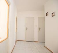 A hallway with light walls and white doors in a 4-room apartment.