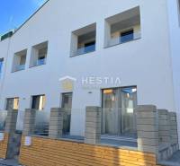 A new building with multiple balconies and a 2-room apartment, a concrete fence, and a terrace.