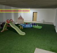 A children's corner with artificial grass, a slide, and a tent in a 2-room apartment.