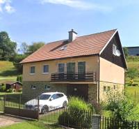 A family house in Liptovské Revúce with a garage and a garden on a sloped plot.