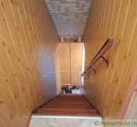 Interior of a family house with wooden wall paneling and a staircase with a wooden decor.
