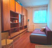 A room with a sofa, cabinets, and a wooden decor floor in a family house.