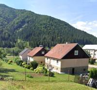 Family houses in Liptovské Revúce with mountain scenery and gardens.