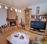 Living room in a family house with a fireplace, wooden floor decor, and a display cabinet.