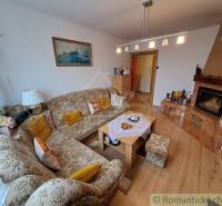 Living room in a family house with an embroidered sofa, alcove kitchen, cozy interior.