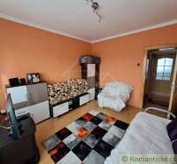 Living room in a family house with furniture, television, and wooden decor flooring.