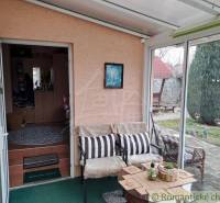 A winter garden in a family house with comfortable seating and a view of the garden.