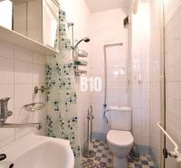 A bathroom in a family house with tiles and a shower corner.