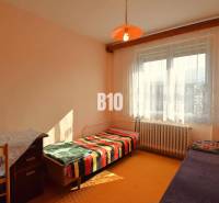 A room in a family house with simple furniture, a bed, and an orange lantern.