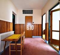 Hallway in a family house with wooden paneling, a table, and a chair.