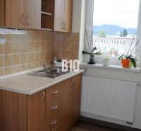 A kitchen with a wooden cabinet and a view from the window, approved by real estate agencies.