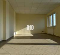 Bright empty room and office with a window and radiator, beige walls.