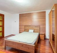 A bedroom in a 5 or more room apartment with a wood-patterned floor, wooden furniture.
