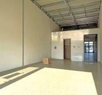 Spacious commercial premises with high ceilings and concrete flooring.