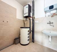 Interior of commercial premises with a heating system, sink, and floor with wood decor.