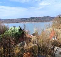 View from the cottage in Holčíkovce at Zajačia debra with a lake and forests in the background.