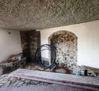 Stone interior with wood-patterned flooring in a cabin.