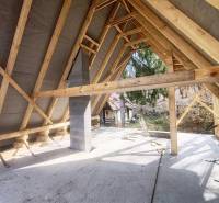 Interior of a cabin with a roof structure and a view of the outside nature.