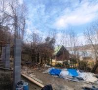 Building material next to the cottage at Zajačia debra in Holčíkovce with a view of the water surface.