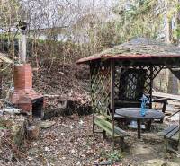 A garden with a gazebo and a brick grill by the cottage at Zajačia debria in Holčíkovce.