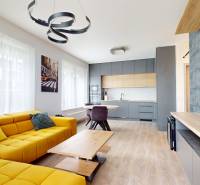 Living room in a 3-room apartment with a wooden decor floor and a yellow sofa.