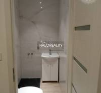 A bathroom in a 3-room apartment with marble-patterned tiles and walls.