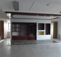 Retail space with shelves and white walls, floor with wood decor.
